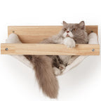 Graue und weiße Langhaarkatze liegt entspannt in Katzenwand Hängematte aus naturbelassenem Massivholz mit weichem Plüsch-Bezug, Soft Hammock Wandmontage